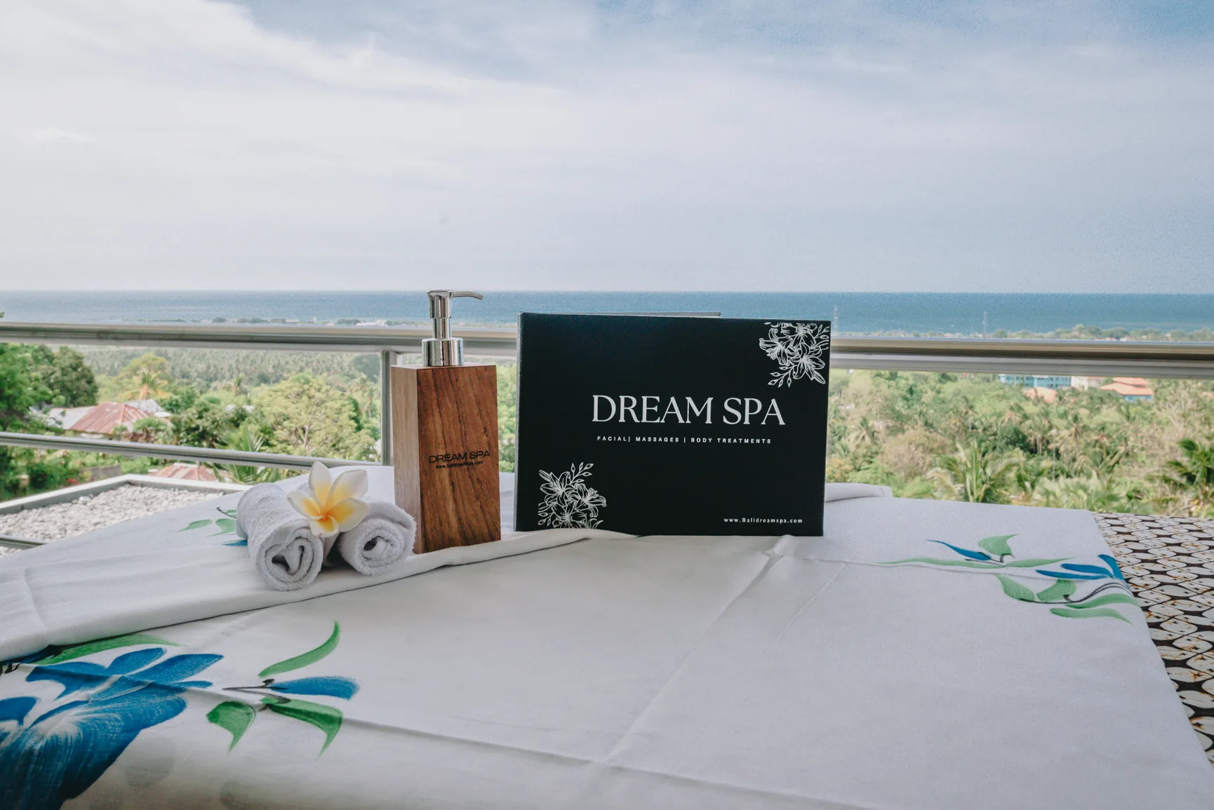Prepared massage table on sea-facing terrace; Dream Spa label visible.